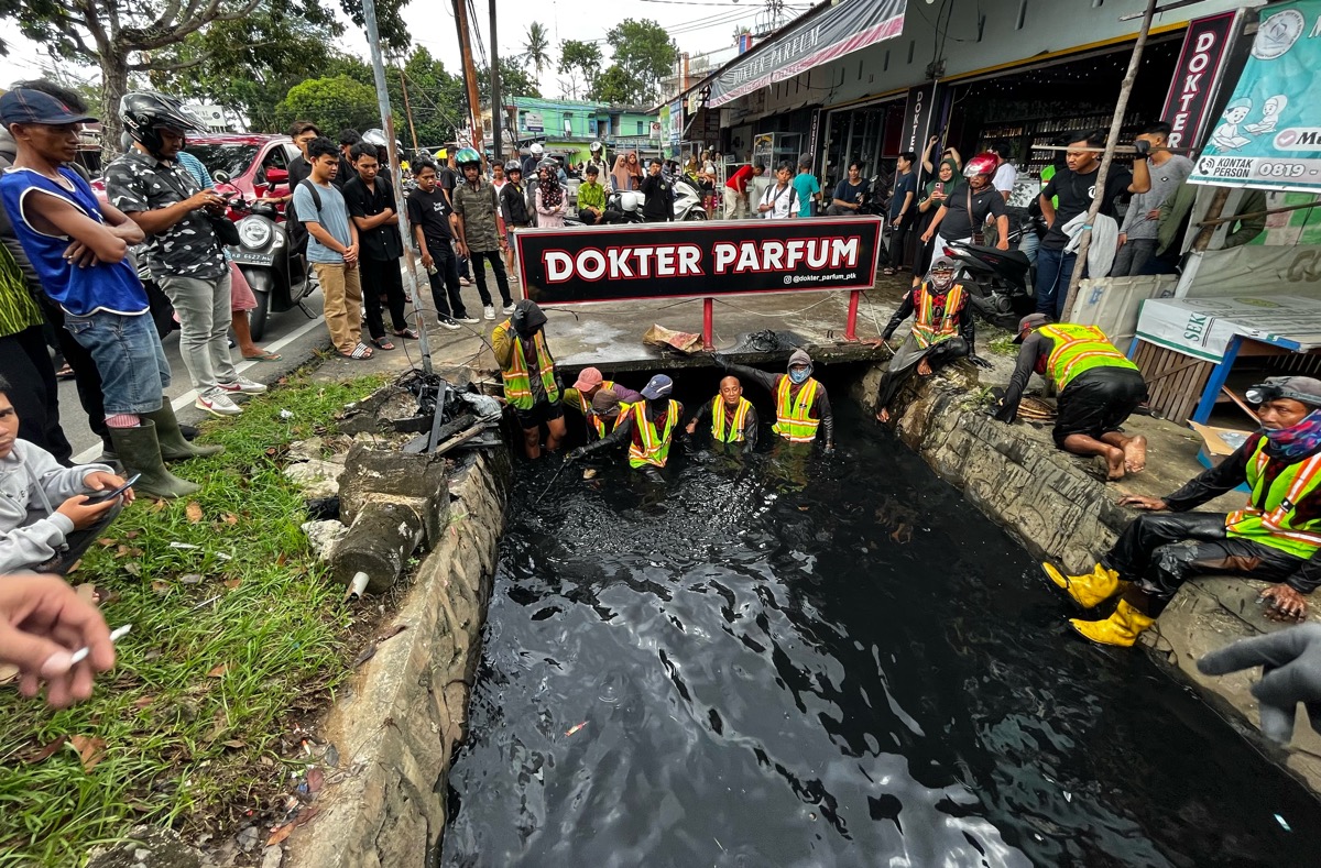 Petugas drainase bersama anggota Polresta Pontianak mencari potongan tulang di selokan Jalan Danau Sentarum.