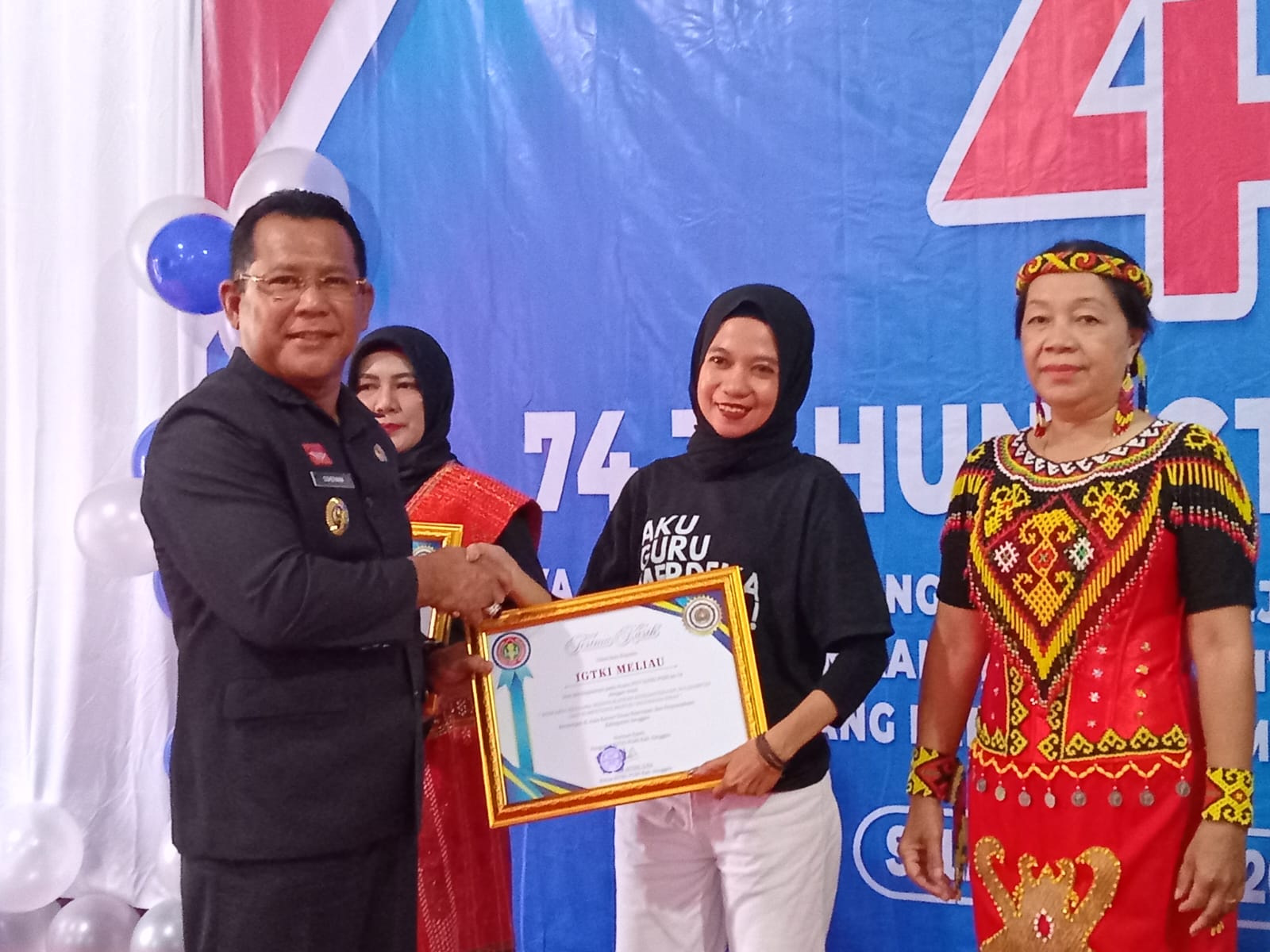 PENGHARGAAN: Pj Bupati Sanggau Suherman menyerahkan penghargaan kepada salah satu guru TK di Sanggau.