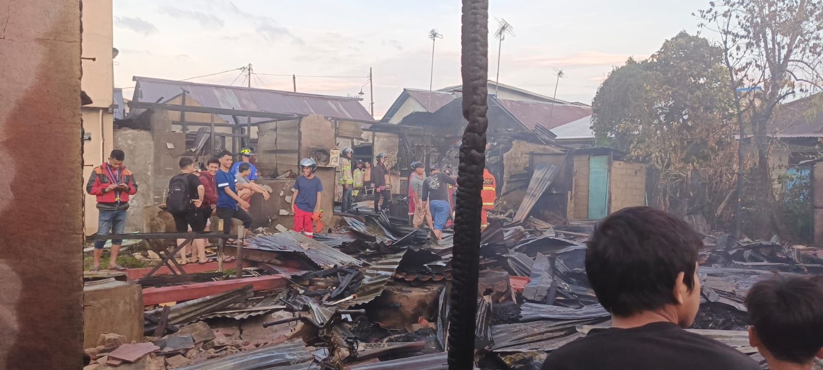 KEBAKARAN: Sejumlah personel kepolisian, bersama pihak Damkar dan warga setempat membantu membersihkan piung-piung lima rumah warga Desa Parit Baru yang hangus dilahap si jago merah.