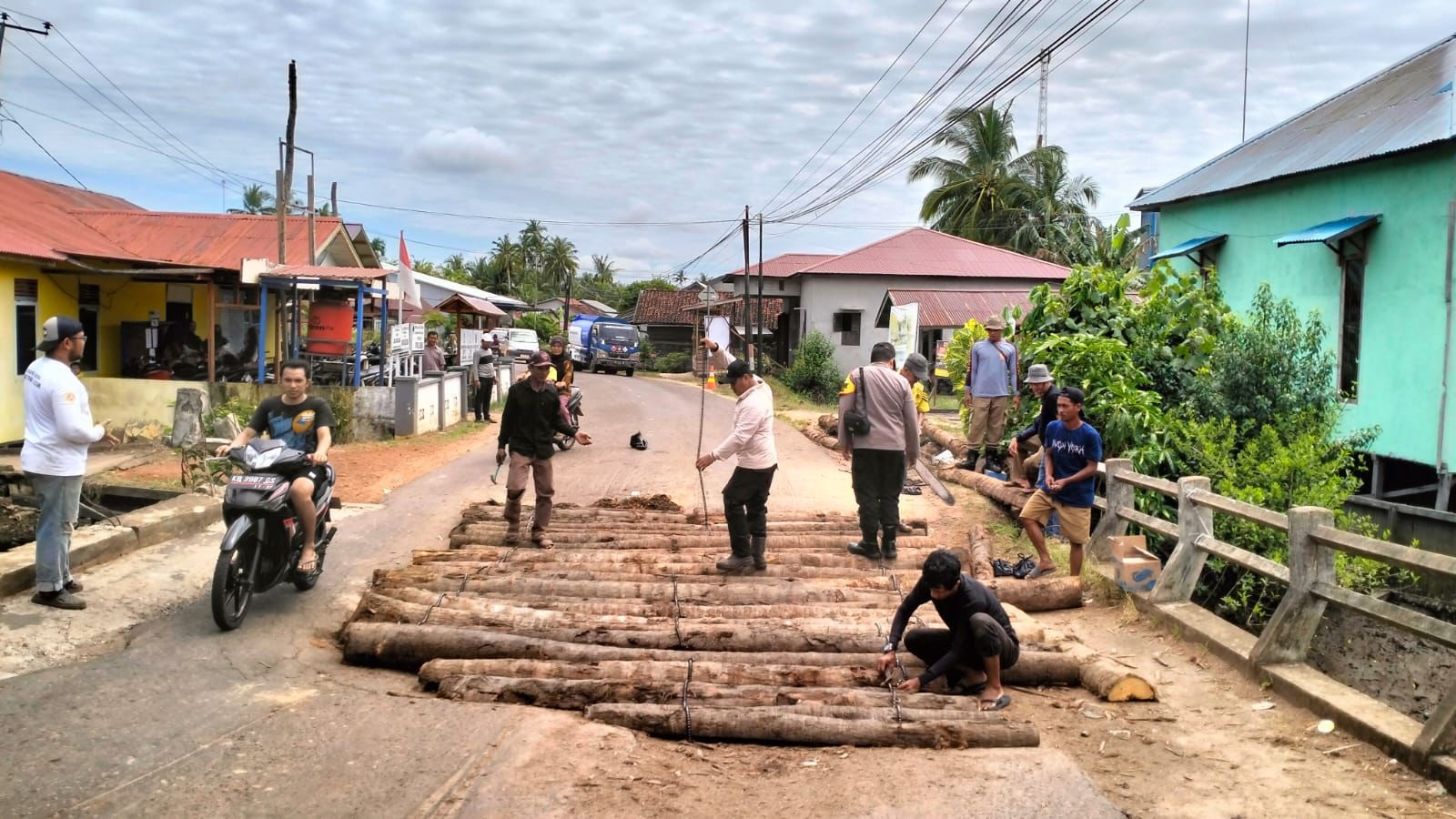 GOTONG ROYONG: Warga bergotong royong memperbaiki jembatan yang rusak di Desa Sungai Besar, Kecamatan MHS, Rabu (3/7).