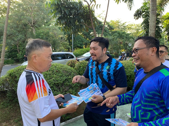 SOSIALISASI: Kepala Bidang Pajak Bapenda Kalbar, Fanny Meivyanto menyerahkan selebaran berisikan informasi tentang program keringanan, dan pembebasan pajak kendaraan bermotor di CFD, Minggu (14/7).