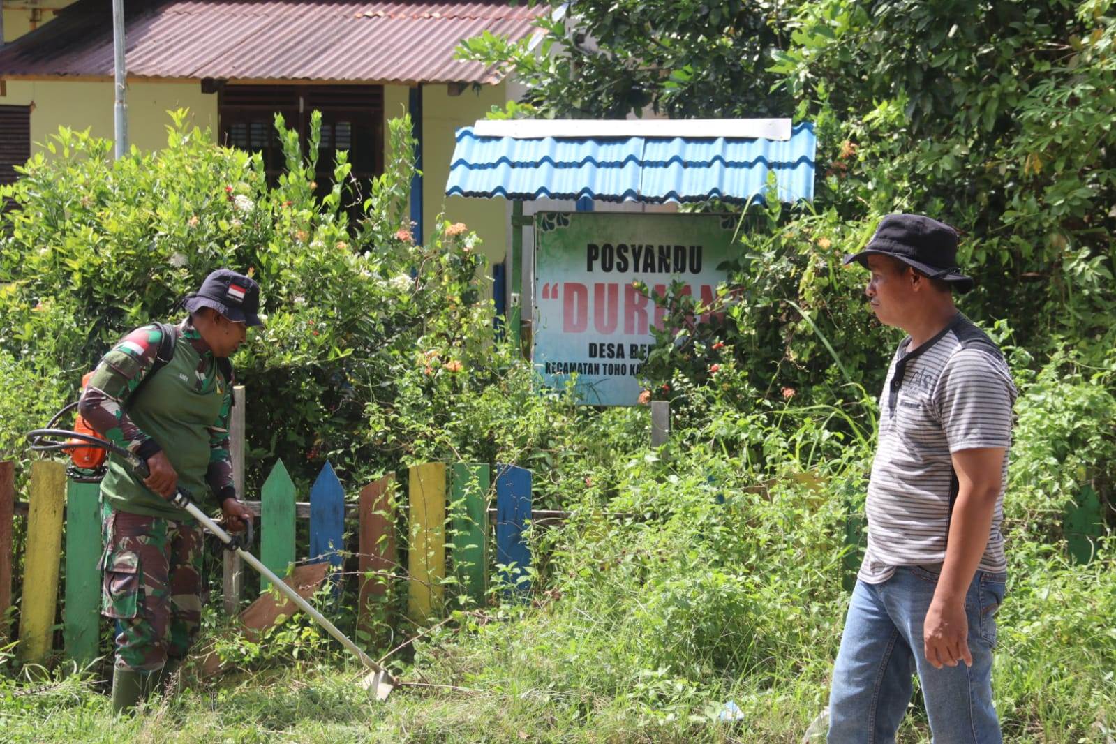 BERSIHKAN LINGKUNGAN: salah seorang prajurit Kodim sedang membersihkan lingkungan Posyandu di Desa Benuang, Kecamatan Toho, Sabtu (20/7).