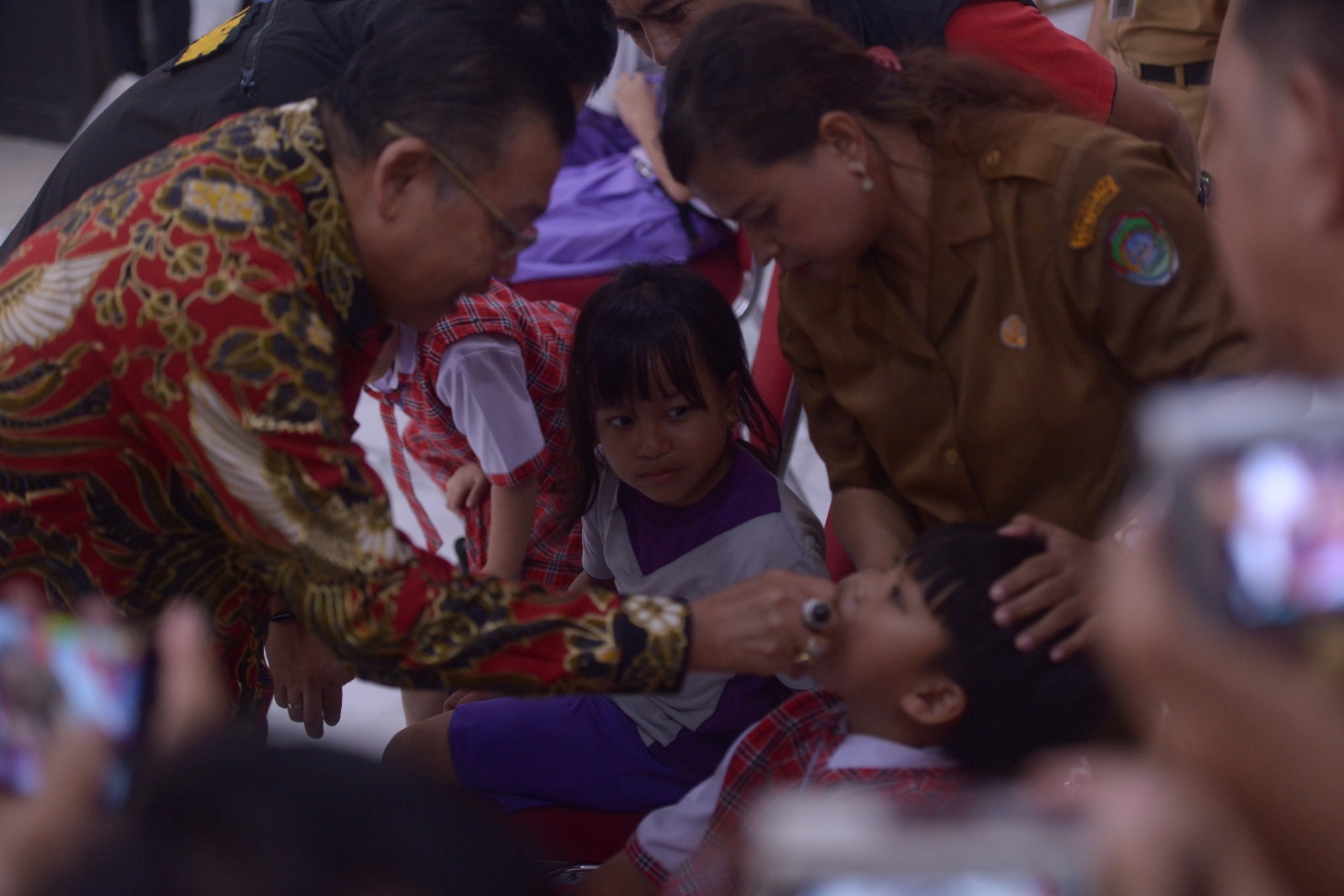 IMUNISASI: Seorang anak memperhatikan temannya yang diberikan imunisasi polio oleh Anggota DPR RI Cornelis di Kantor Dinas Kesehatan Kabupaten Landak, Selasa (23/7).