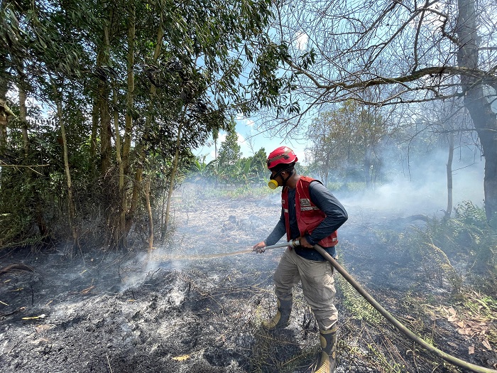 PADAMKAN API : Salah satu pemadam dari PMI Kalbar sedang memadamkan kebakaran lahan di Jalan Reformasi beberapa waktu lalu.