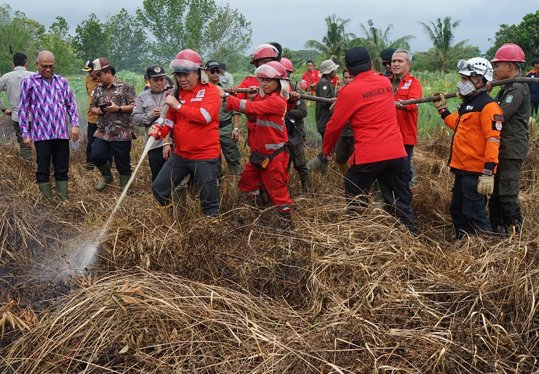 Dirjen Perhutanan Sosial dan Kemitraan Lingkungan Hidup dan Kehutanan RI, Mahfudz didampingi Kadis DLHK Provinsi Kalbar, Adi Yani saat melakukan penyemprotan di lahan terbakar Desa Rasau Jaya Umum.