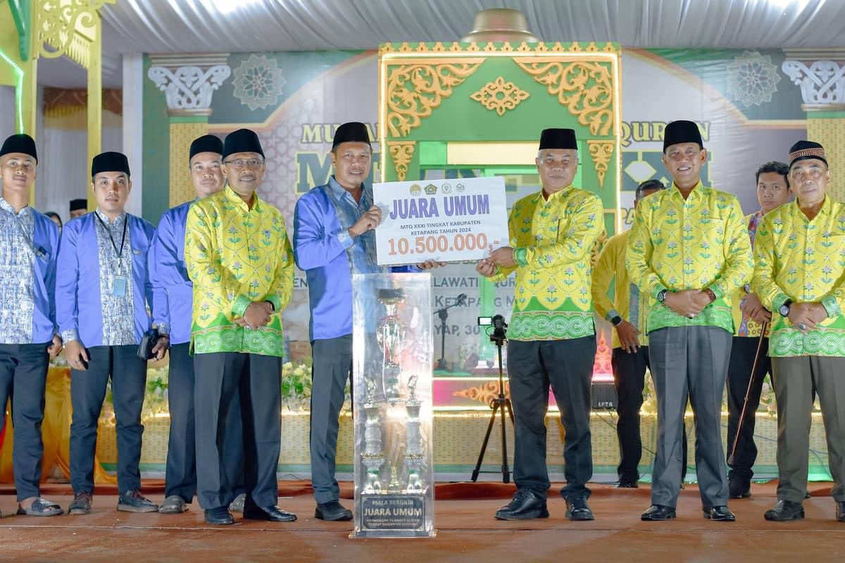 SERAHKAN PIALA: Bupati Ketapang, Martin Rantan, menyerahkan piala kepada perwakilan Delta Pawan yang menjadi juara umum pada MTQ XXXI Ketapang di Nanga Tayap.