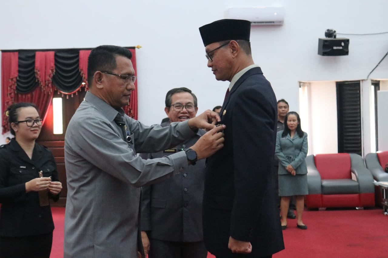 TANDA KEHORMATAN: Pj Bupati Landak, Gutmen Nainggolan, saat menyematkan tanda kehormatan Satyalancana Karya Satya kepada PNS di lingkungan Pemkab Landak.