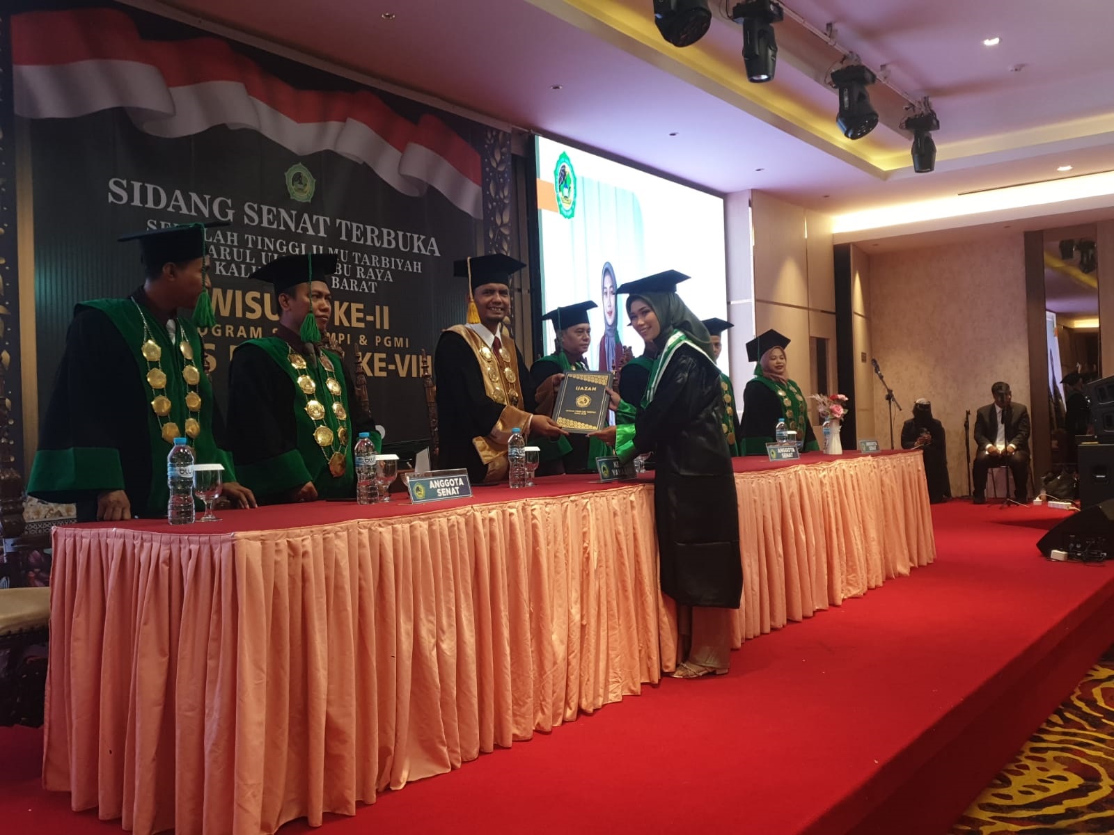 WISUDA: Seorang wisudawati menerima ijazah dari Ketua STITDAR Kubu Raya, Imam Sanusi di Ballroom Hotel Alimoer, Jl A Yani II, Minggu (11/8).