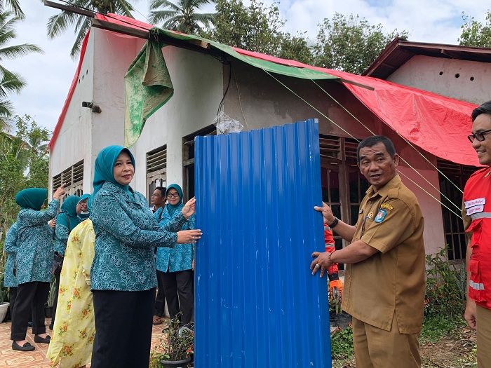 SERAHKAN: Pj Ketua TP-PKK Kalbar Windy Prihastari secara simbolis menyerahkan bantuan seng kepada warga terdampak puting beliung di&nbsp;Desa Pal 9, Kabupaten Kubu Raya, Selasa (13/8).&nbsp;