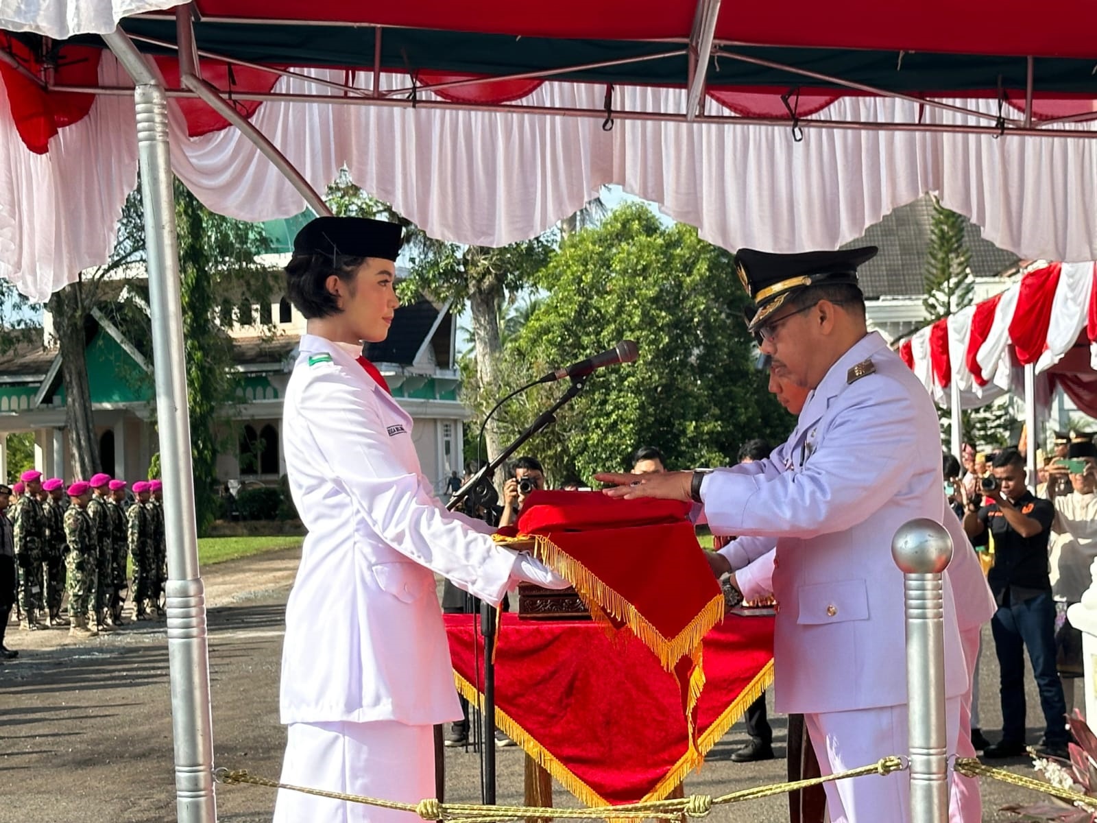PENYERAHAN: Penjabat Bupati Ismail menyerahkan Merah Putih kepada Paskibra pembawa baki.