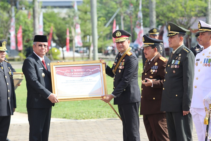 PENGHARGAAN: Pj Gubernur Harisson menyerahkan piagam penghargaan kepada Kapolda Kalbar usai&nbsp;apel Hari Pengayoman ke-79 di Halaman Kantor Gubernur, Senin (19/8).