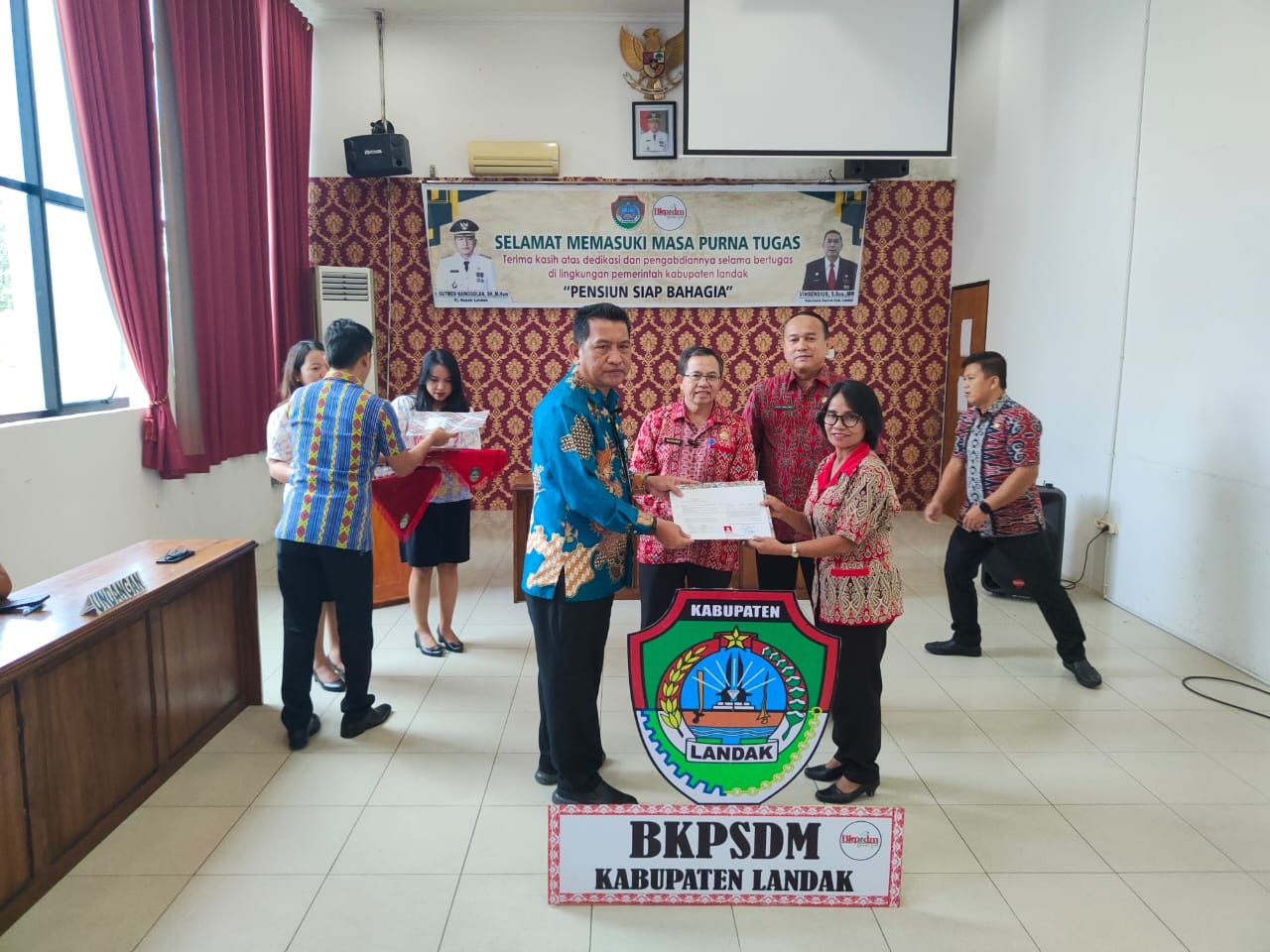 SERAHKAN: Pj Bupati Landak, Gutmen Nainggolan saat menyerahkan SK pensiun kepada PNS yang memasuki masa pensiun.