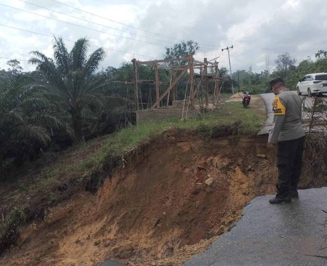 LONGSOR: Bhabinkamtibmas Polsek Kuala Behe saat melakukan kegiatan monitoring di lokasi longsor di Dusun Engkalong, Desa Nyayum, Kecamatan Kuala Behe, Kabupaten Landak. (ISTIMEWA)
