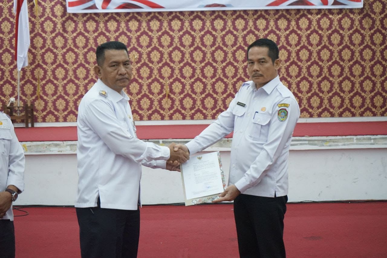 SURAT KEPUTUSAN: Pj Bupati Landak Gutmen Nainggolan saat menyerahkan SK Plh Sekda Landak kepada Heri Adiwijaya, Inspektur Kabupaten Landak di aula Kantor Bupati Lndak.
