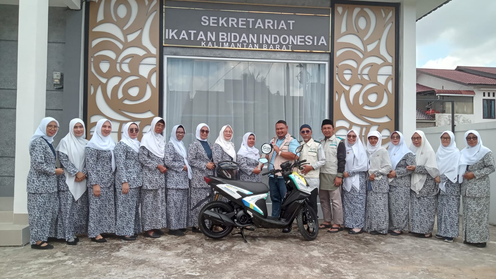 Bidan Emy Rahimi didampingi pengurus IBI Kalbar saat mendapatkan satu unit motor listrik dari YBM PLN untuk menunjang aktivitasnya, Sabtu (31/8).(MARSITA /PONTIANAK POST)