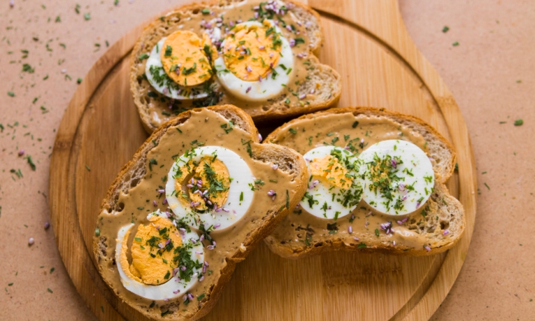 ilustrasi telur rebus di atas roti gandum