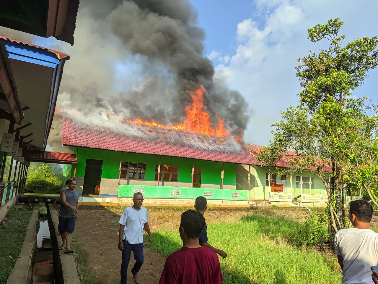 TERBAKAR: Api menyala dia atap bangunan LAP dan Perpustakaan di SMP N 3 Sukadana, Kabupaten Kayong Utara, Kalimantan Barat Selasa (3/9).(ISTIMEWA)