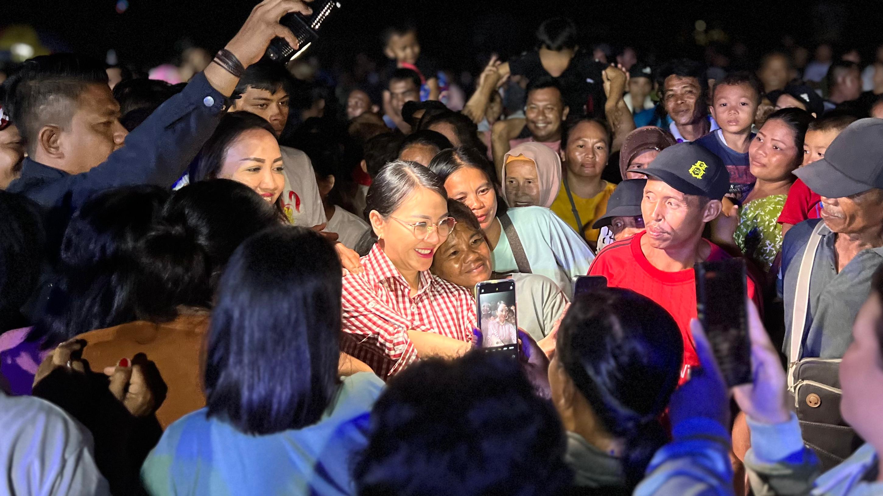 BERFOTO BERSAMA: Masyarakat mengerubungi Karolin Margret Natasa untuk berfoto bersama pada penutupan turnamen speak bola Raksauda Cup di Desa Sebangki, Kecamatan Sebangki.