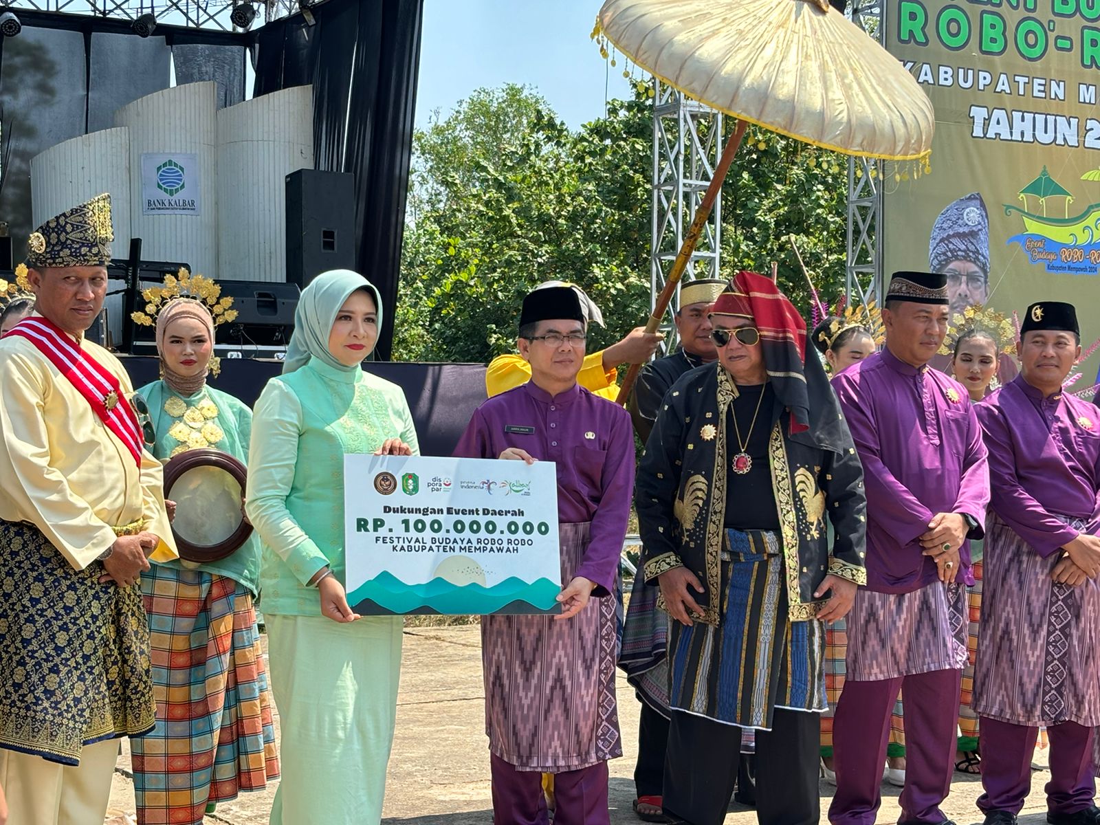 SERAHKAN : Kepala Disporapar Kalbar Windy menyerahkan secara simbolis dukungan event daerah kepada Pj Sekda Mempawah untuk Festival Robo-Robo Mempawah saat seremoni pembukaan, Rabu (4/9).