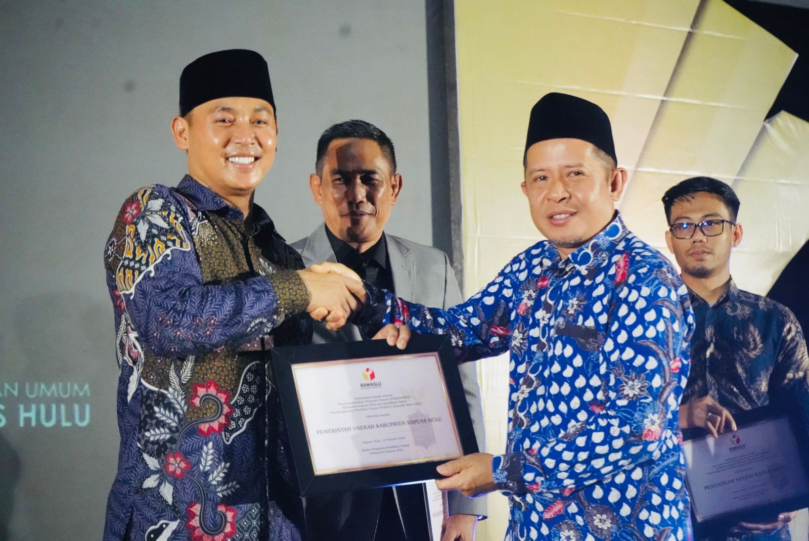 PENGHARGAAN : Ketua Bawaslu Kapuas Hulu Mustaan saat menyerahkan penghargaan kepada Pemkab Kapuas Hulu atas dukungan terhadap mereka selama ini.