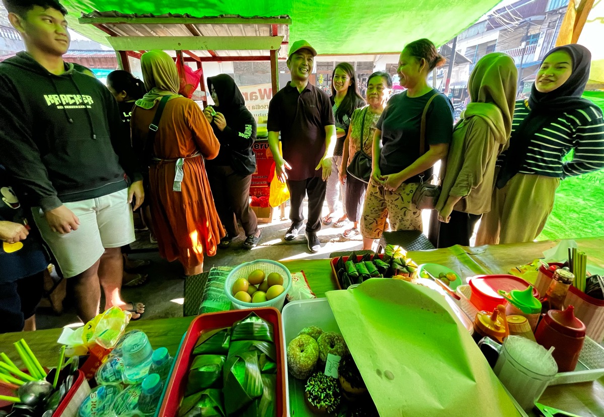 Ria Norsan makan bubur bersama warga Ngabang saat berolahraga mengelilingi pasar pagi di Ngabang, Sabtu (7/9)