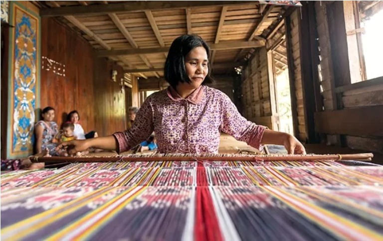 SAKRAL: Warga Dayak Iban menenun menggunakan alat tradisional di Kapuas Hulu. Sebelum mulai, penenun harus melakukan ritual dan doa. DOKUMEN