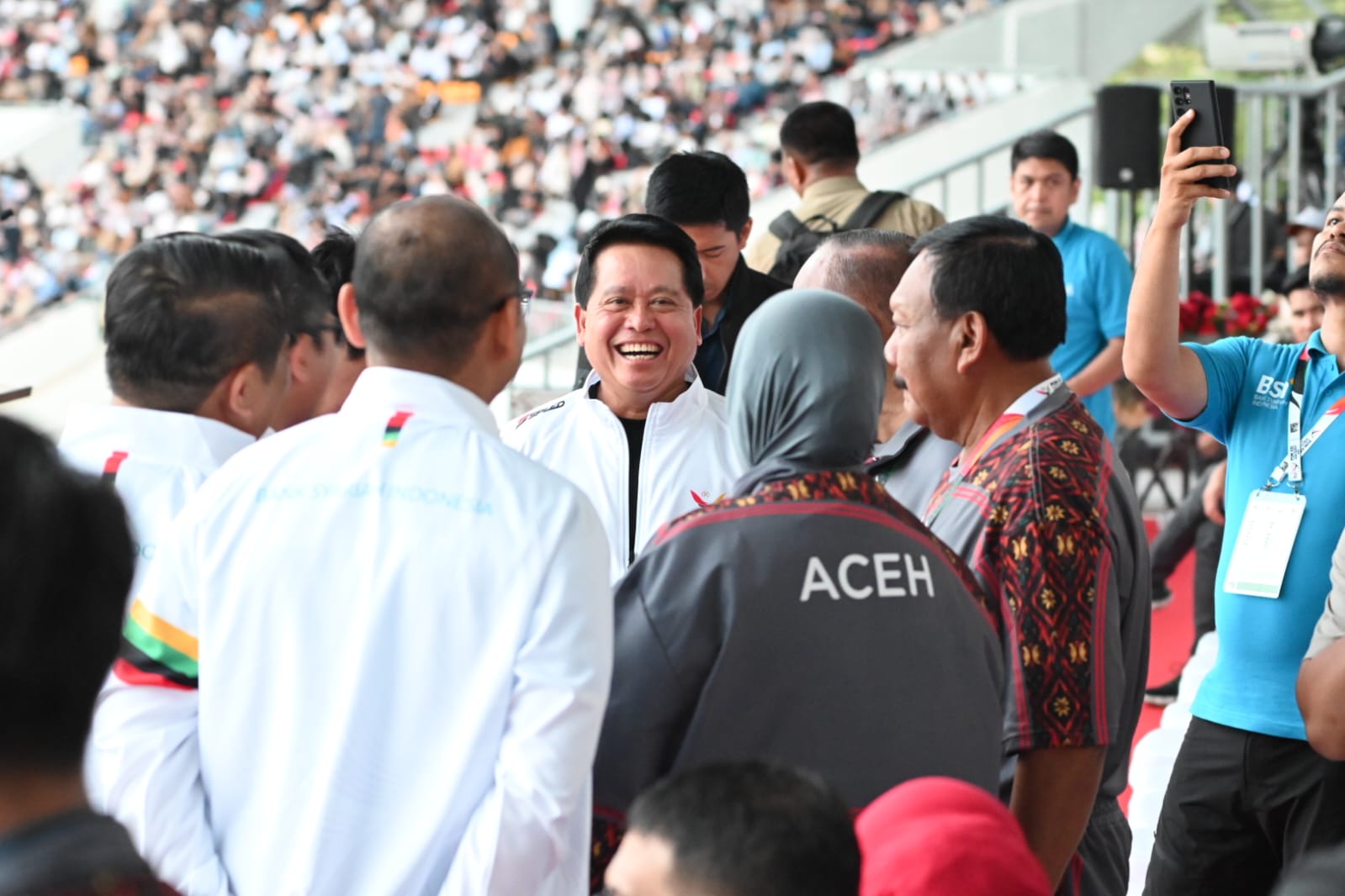 Direktur Utama BSI Hery Gunardi (tengah) berbincang dengan jajaran Direksi BSI dan stakeholder saat menghadiri Upacara Pembukaan PON Aceh - Sumut XXI 2024 yang dibuka oleh Presiden Republik Indonesia.