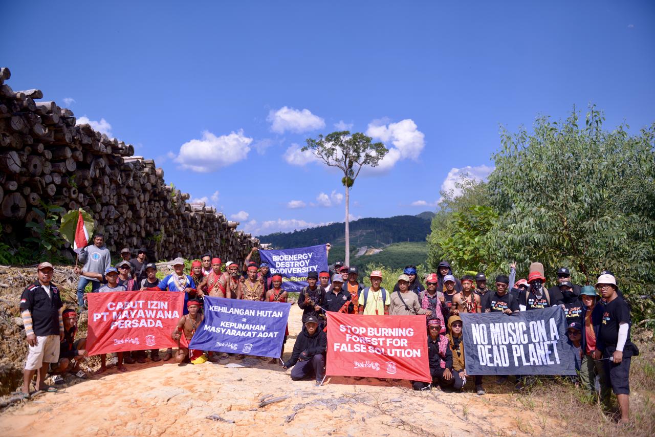 Masyarakat adat Desa Kualan bersama organisasi Masyarakat sipil dan Musisi membentangkan spanduk di konsesi PT. Mayawana Persada.