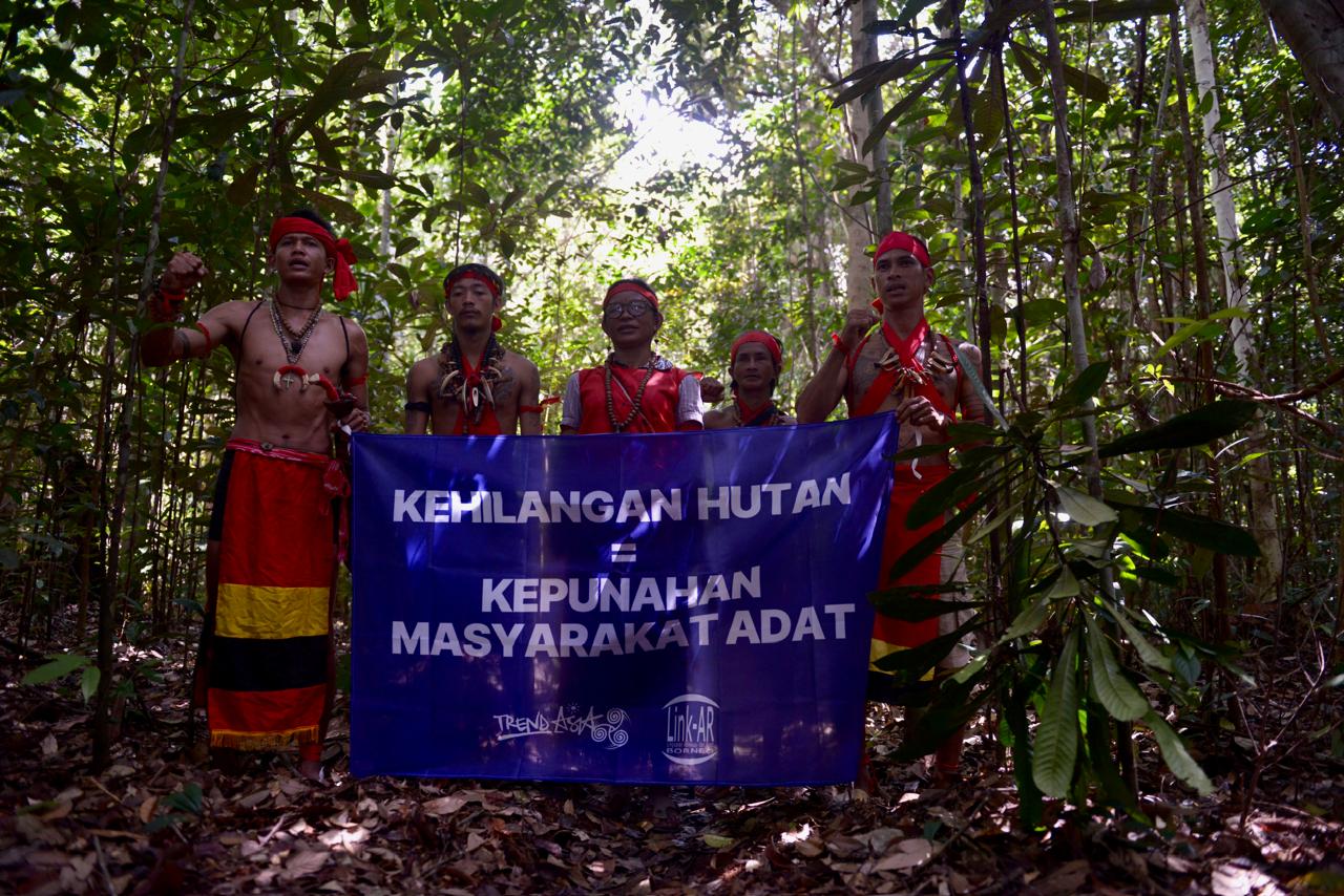 Masyarakat Adat Desa Kualan membentangkan spanduk bertuliskan &ldquo;Hilangnya Hutan=Kepunahan Masyarakat Adat&rdquo; di hutan milik Masyarakat.