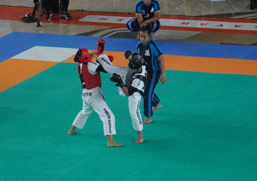 Raisha (kanan hitam) menendang telak lawannya atlet asal Kaltim di laga final  tarung derajat kelas 54,1 kg-58 kg.