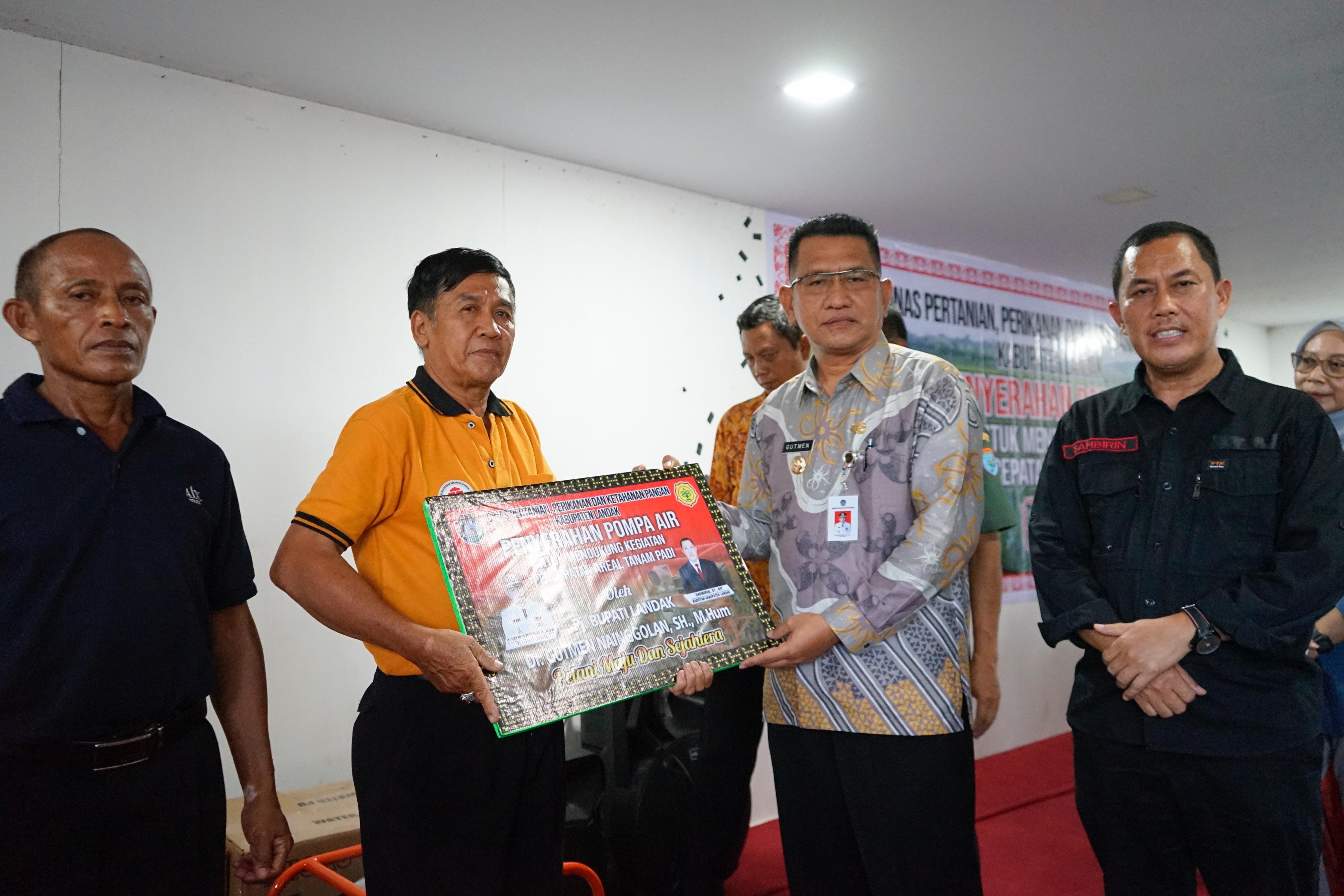 SIMBOLIS: Pj Bupati Landak Gutmen Nainggolan saat menyerahkan secara simbolis alat dan mesin pertanian berupa pompa air kepada kelompok tani di Aula Dinas PPKP Landak.