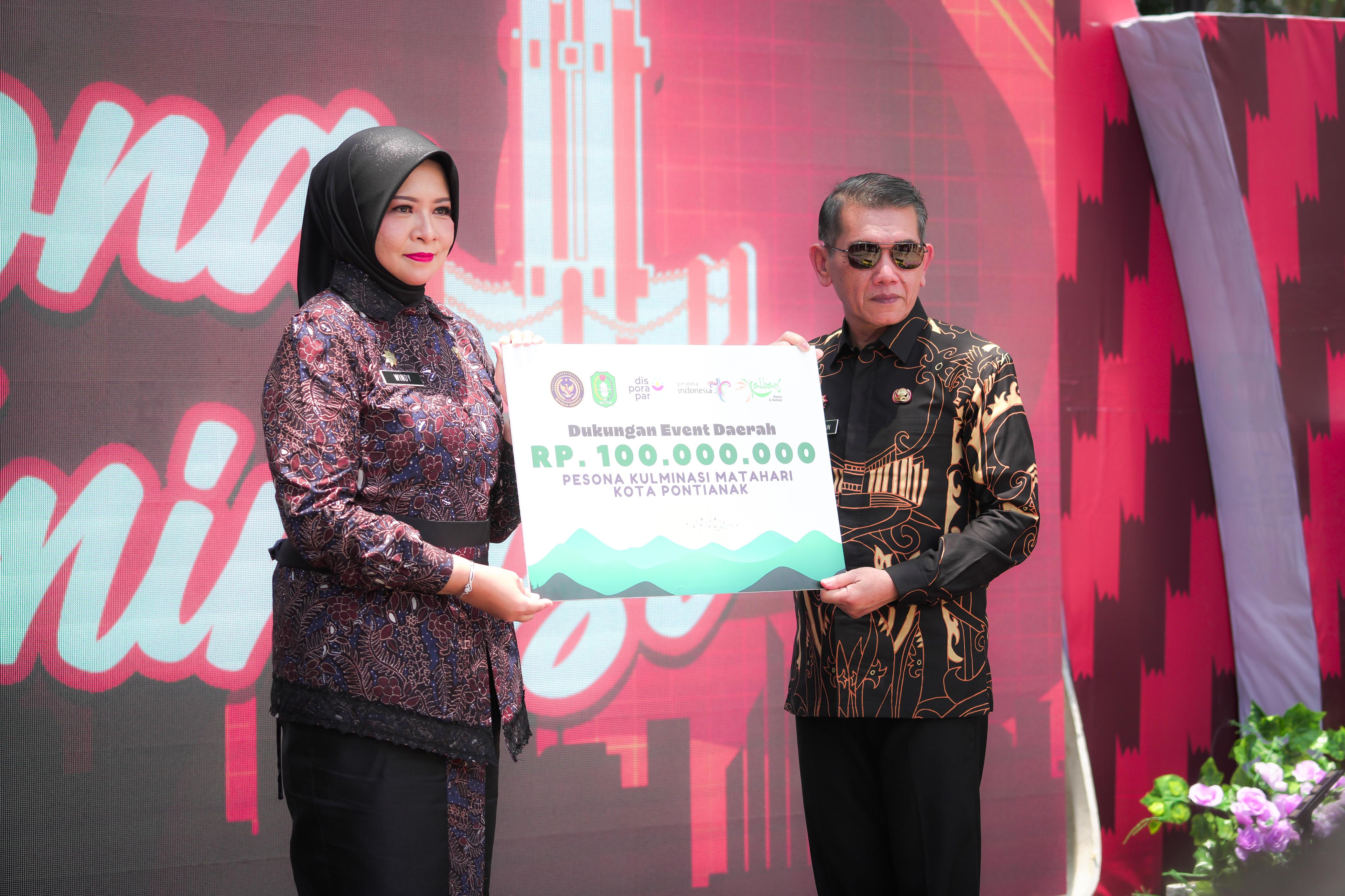 DUKUNG EVENT: Kepala Disporapar Kalbar, Windy Prihastari menyerahkan secara simbolis dukungan event daerah, serta mock up, dan memorative goods event untuk Pesona Kulminasi Matahari kepada Ani Sofian.
