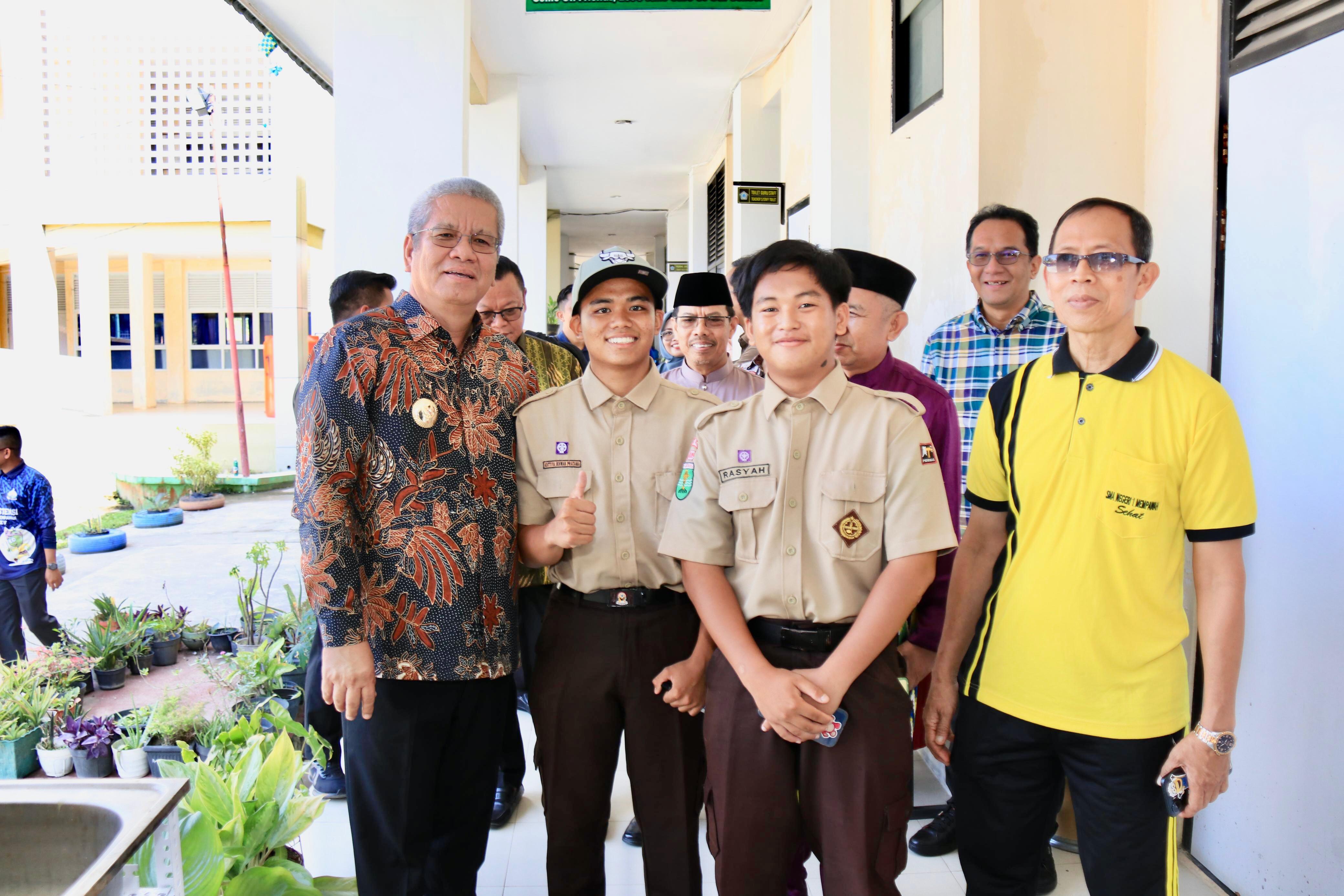TINJAU : Pj Gubernur Harisson foto bersama pelajar yang dihadiahi topi saat berkunjung ke SMAN 1 Mempawah, Jumat (27/9).