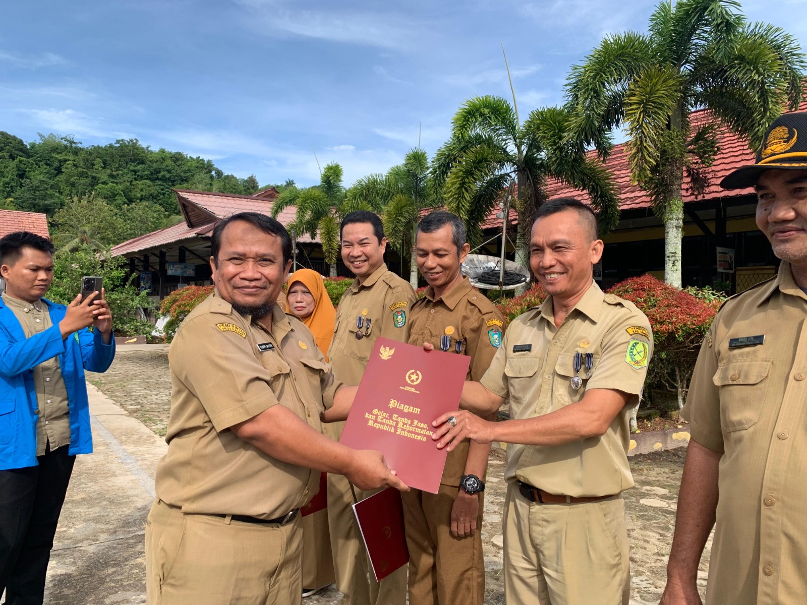 PENGHARGAAN: Kepala SMAN 1 Selakau, Yushfi Jauhari, menyerahkan penghargaan Satya Lencana Karya Satya dari Presiden RI Joko Widodo saat upacara bendera di halaman sekolah.