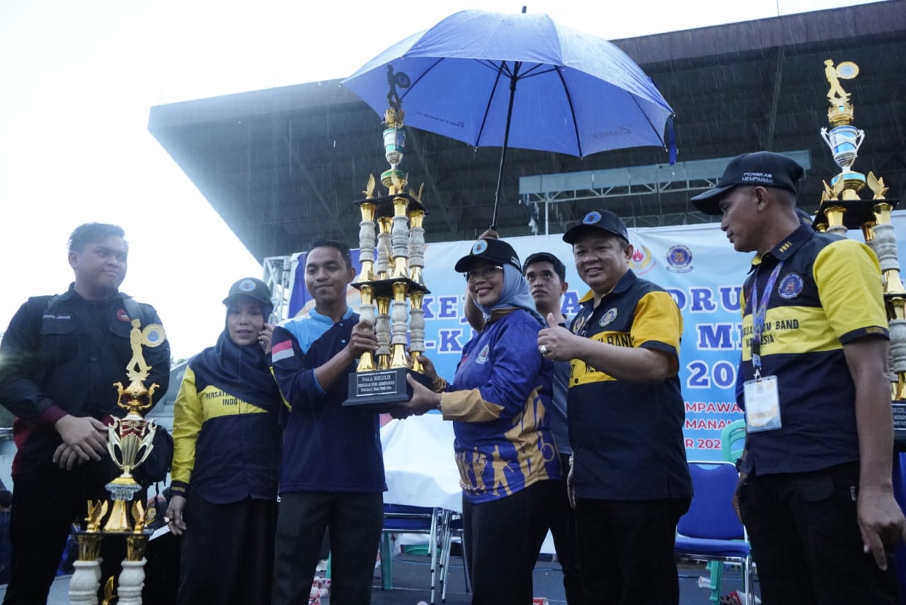 PIALA : Hj Erlina menyerahkan piala kepada pemenang kejuaraan drum band se-Kabupaten Mempawah.