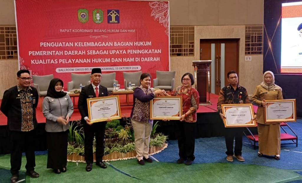PENGHARGAAN : Kabag Hukum Setda Sanggau, Marina Rona saat menerima piagam penghargaan dari Pemprov Kalbar, Selasa (15/10).