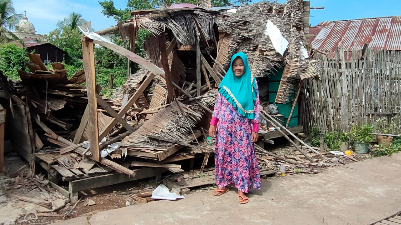 ROBOH: Korban menunjukkan kondisi rumahnya yang roboh diterjang angin kencang.