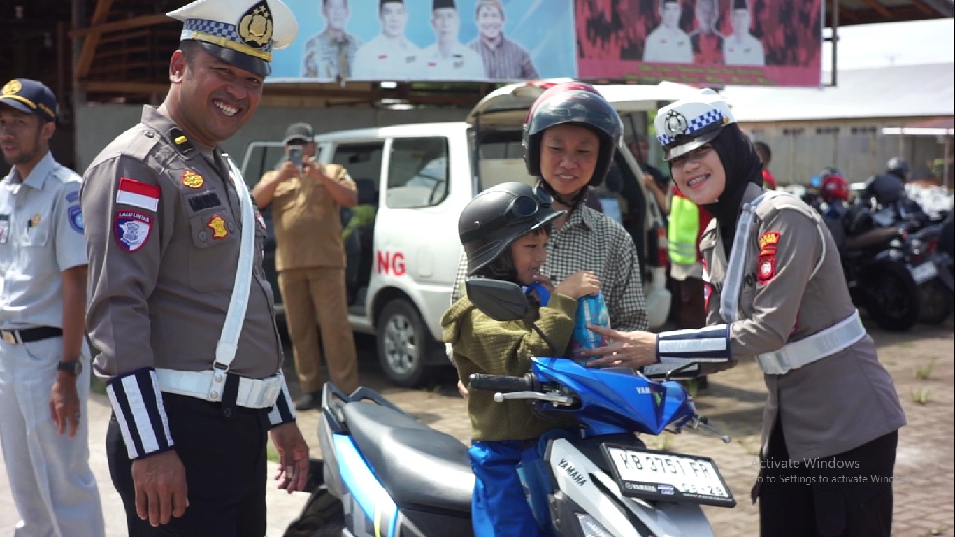 PATUH: Polisi saat memberikan hadiah kepada anak yang menggunakan helm dalam Operasi Zebra Kapuas.&nbsp;
