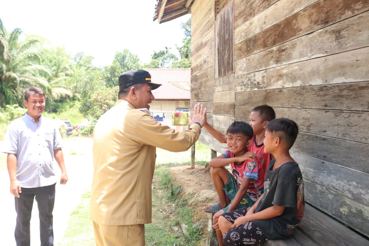 BERSUA: Pj Bupati Landak Gutmen Nainggolan saat menyapa anak-anak usai sosialisasi bantuan rumah tak layak huni (RTLH) di Desa Papung, Kecamatan Jelimpo.&nbsp;
