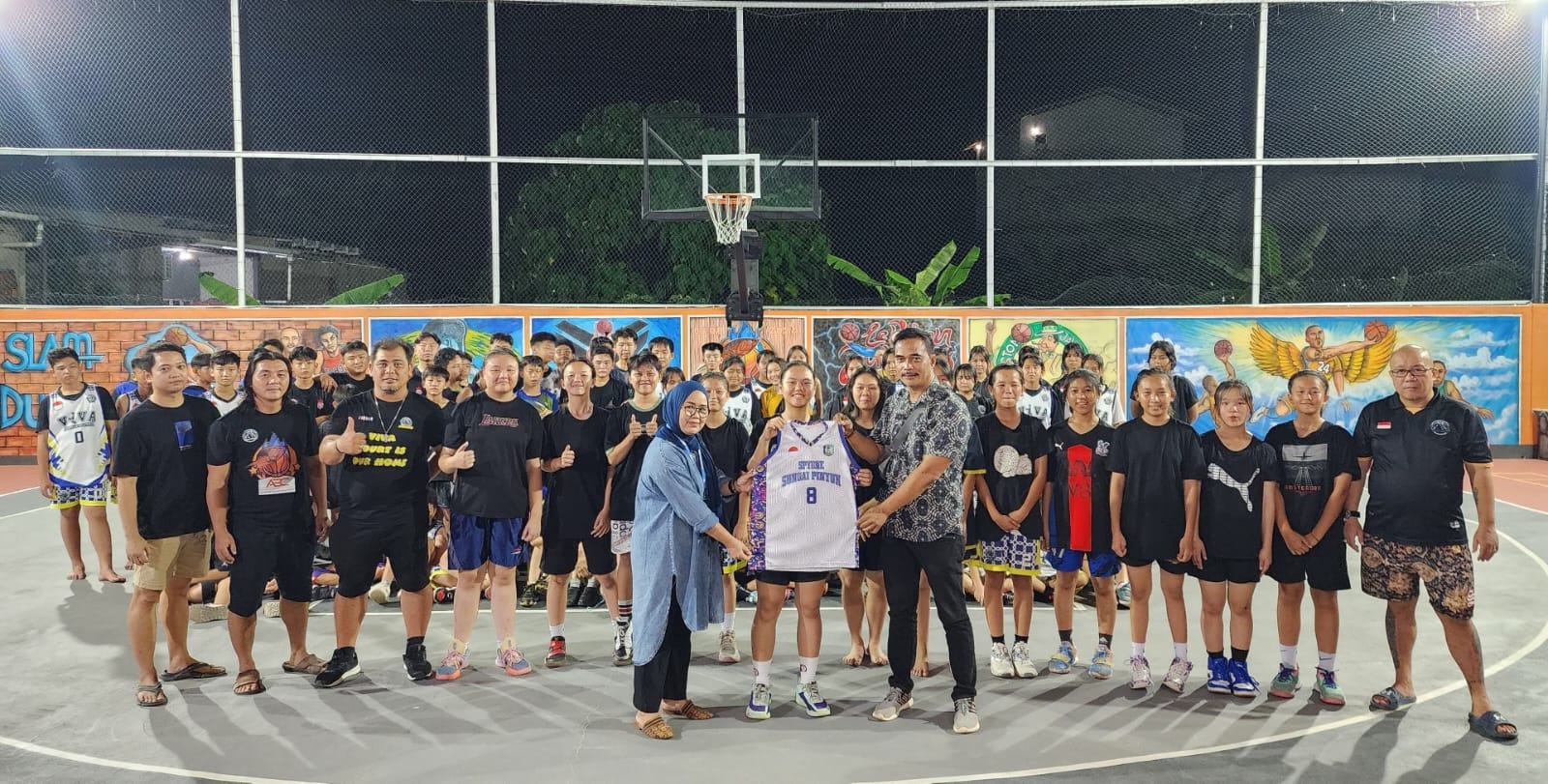 SERAGAM: Ketua Tim Pemenangan Pasangan TERUJI Sungai Pinyuh menyerahkan seragam untuk tim basket viva sungai pinyuh.