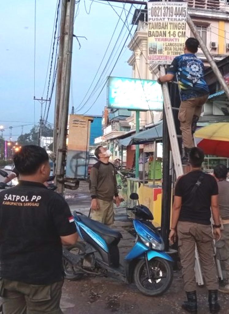 PENERTIBAN : Satpol PP Sanggau saat melakukan penertiban terhadap papan reklame yang habis masa izin, tidak berizin maupun salah penempatan.