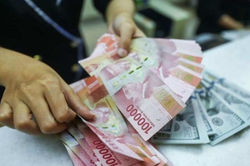 Petugas menghitung uang pecahan dolar AS dan Rupiah (25/4/2024).