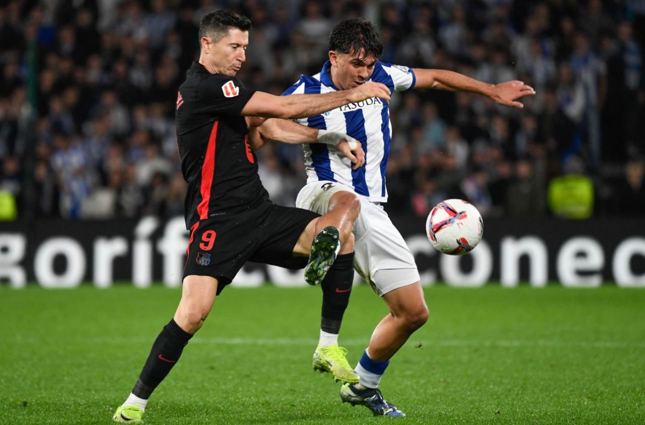 Pemain Barcelona Robert Lewandowski berduel dengan pemain Real Sociedad pada laga Senin dini hari WIB.