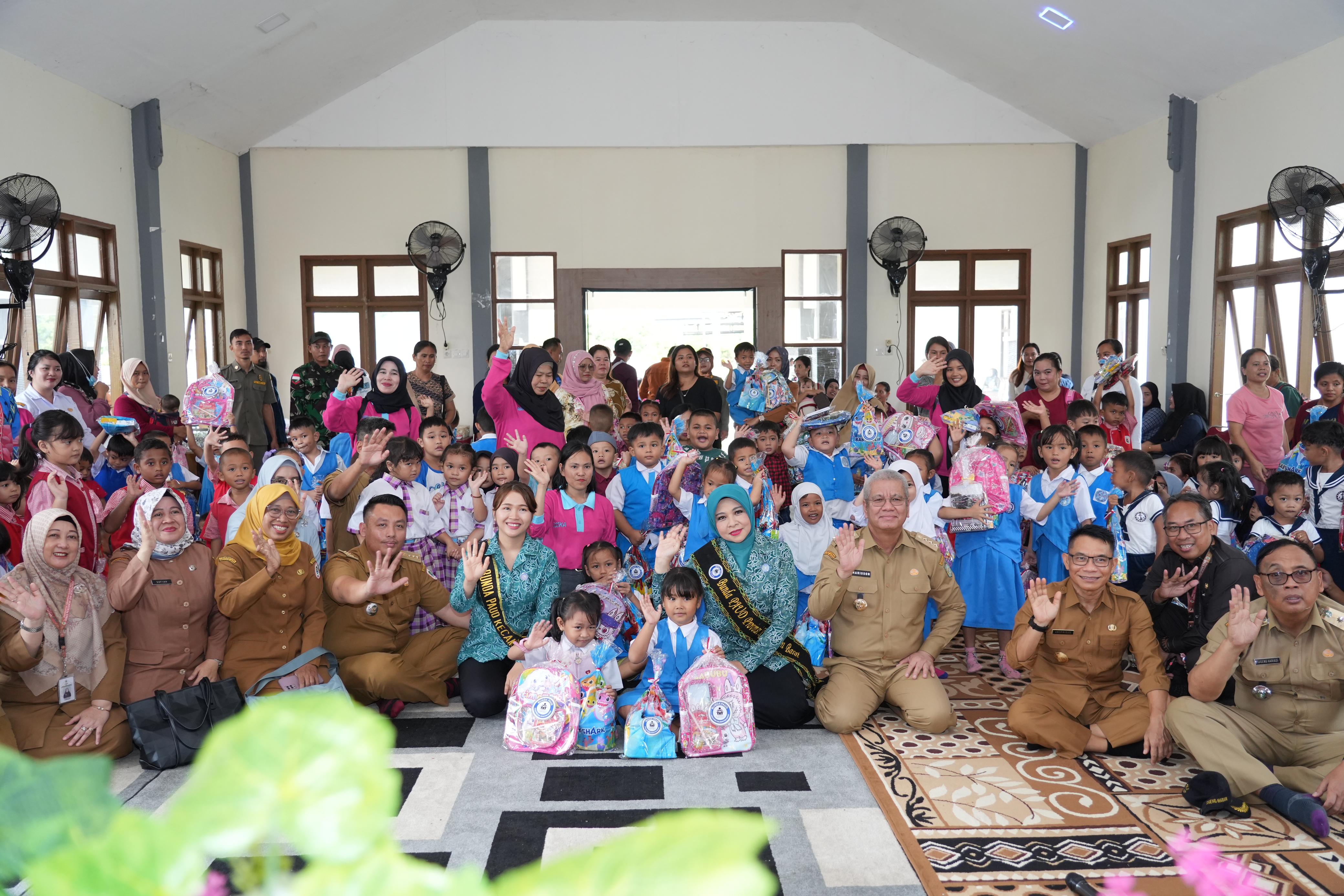 Pj Gubernur Harisson bersama Pj Ketua TP-PKK Kalbar Windy foto bersama usai menyerahkan bantuan paket alat belajar, dan sarapan sehat di Kantor Camat Badau, Kabupaten Kapuas Hulu, Senin (11/11).