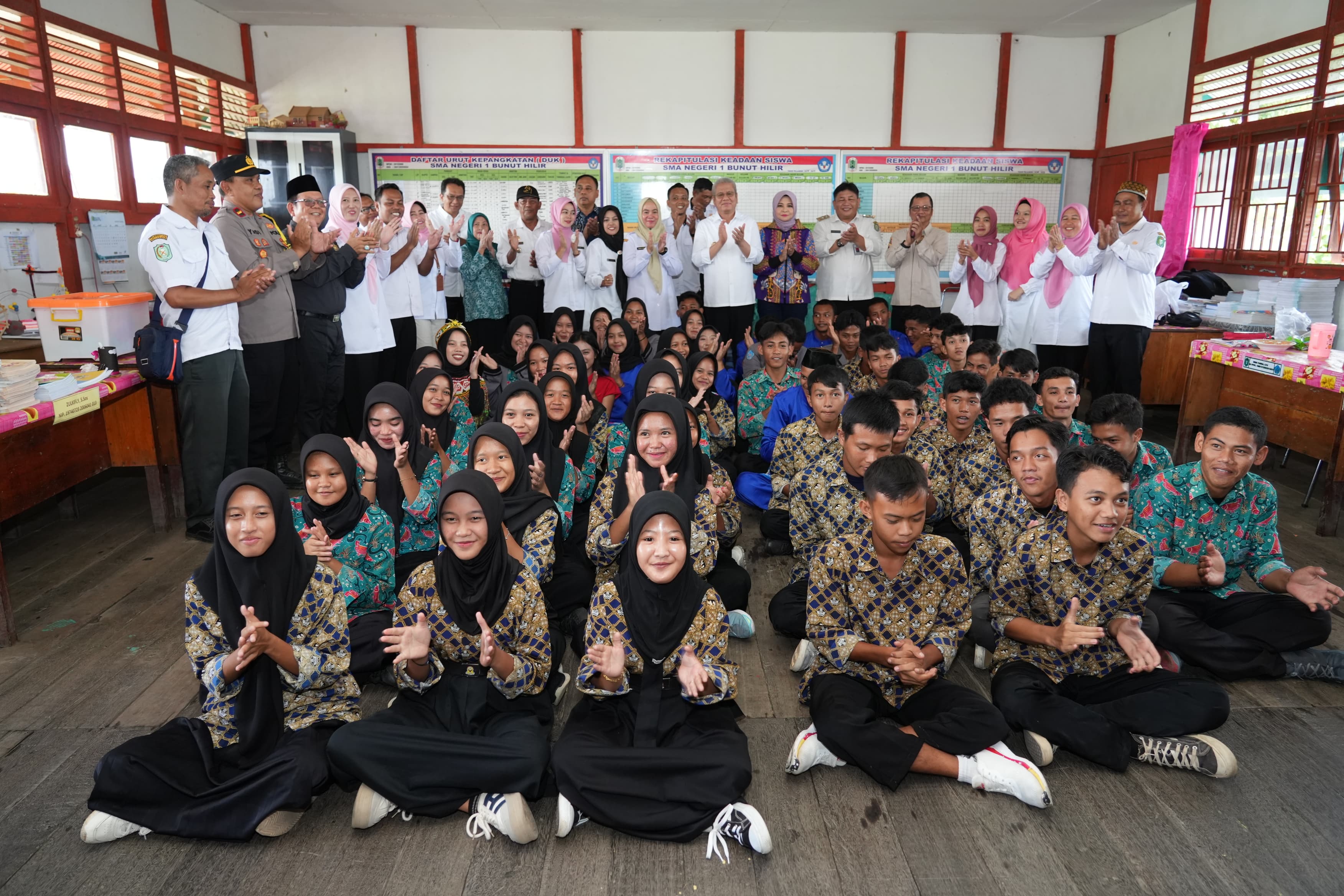 BERSAMA PELAJAR: Pj Gubernur Kalbar Harisson bersama Pj Ketua TP-PKK Kalbar Windy foto bersama para pelajar saat berkunjung ke SMA Negeri 1 Bunut Hilir, Kabupaten Kapuas Hulu, Rabu (13/11).