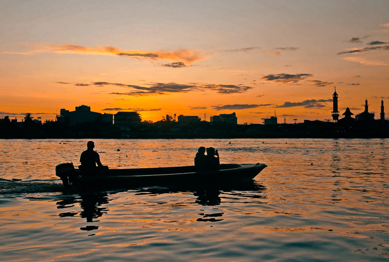 BERBURU SENJA: Sebuah sampan membawa penumpang mengitari Sungai Kapuas sambil menikmati senja di sore hari.