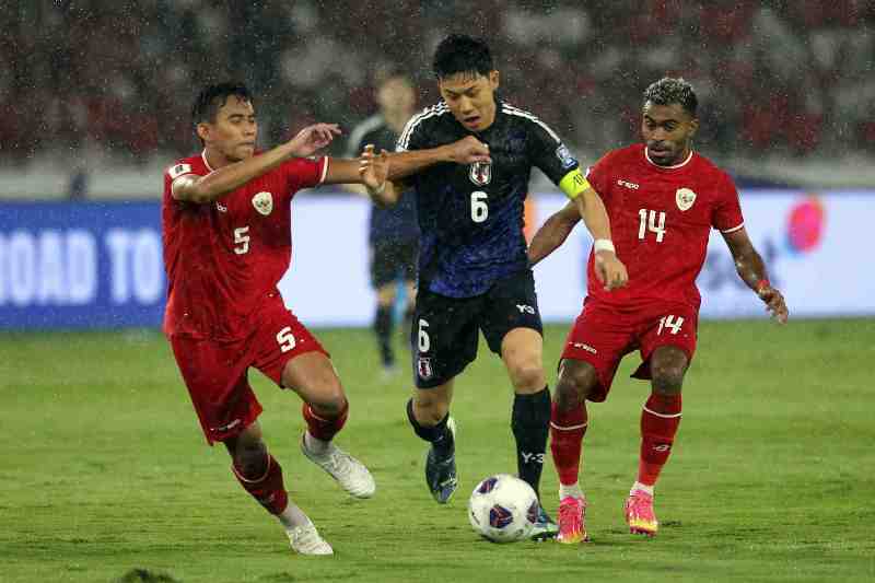 Pesepak bola timnas Jepang, Wataru Endo (tengah) ditempel dua pemain Indonesia pada laga Kualifikasi Piala Dunia Zona Asia di Stadion Utama Gelora Bung Karno (SUGBK), Jakarta, Jumat (15/11).