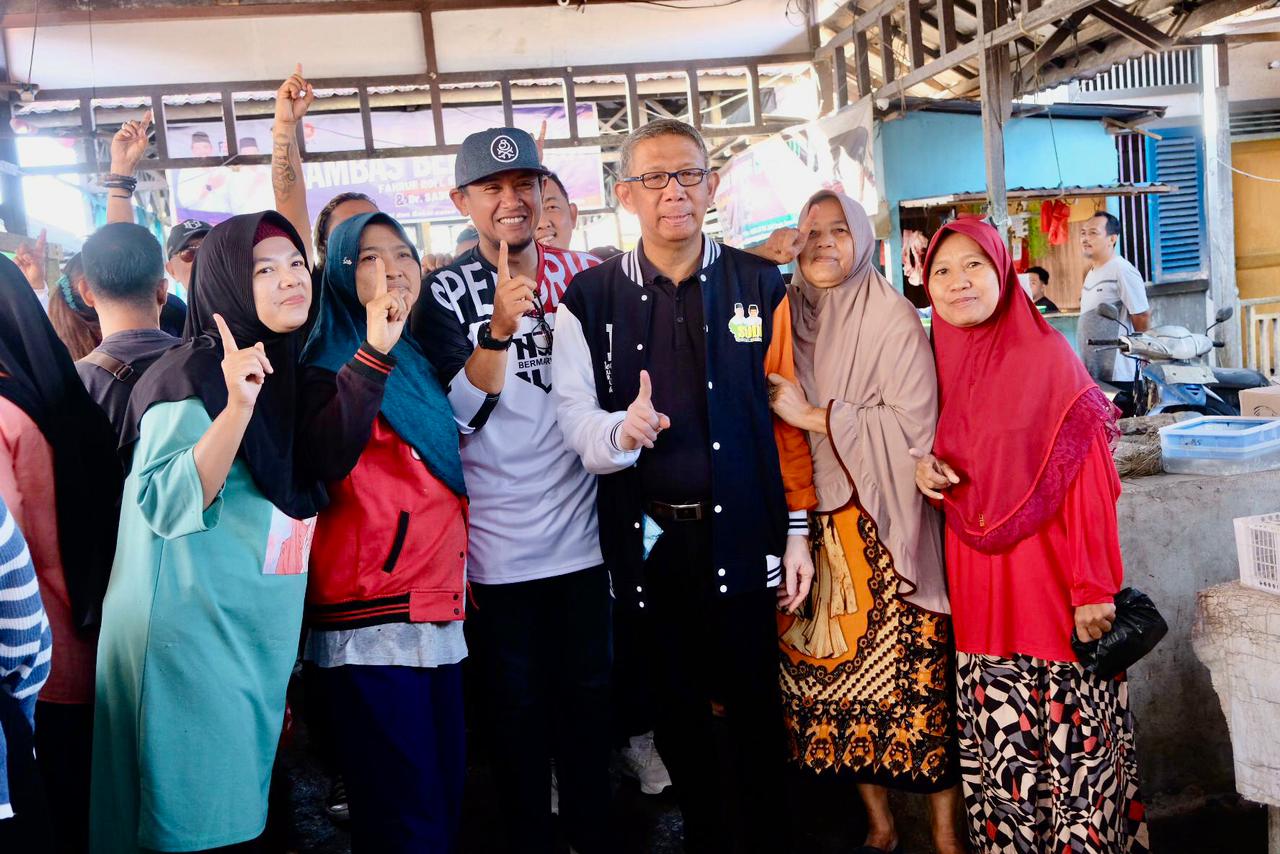 BERSAMA : Cagub Kalbar nomor urut 1, Sutarmidji bersama Cabup Sambas nomor urut 1, Fahrur Rofi foto bersama warga di Pasar Pagi, Jalan Pendidikan, Desa Cagur, Kecamatan Sambas, Kabupaten Sambas.