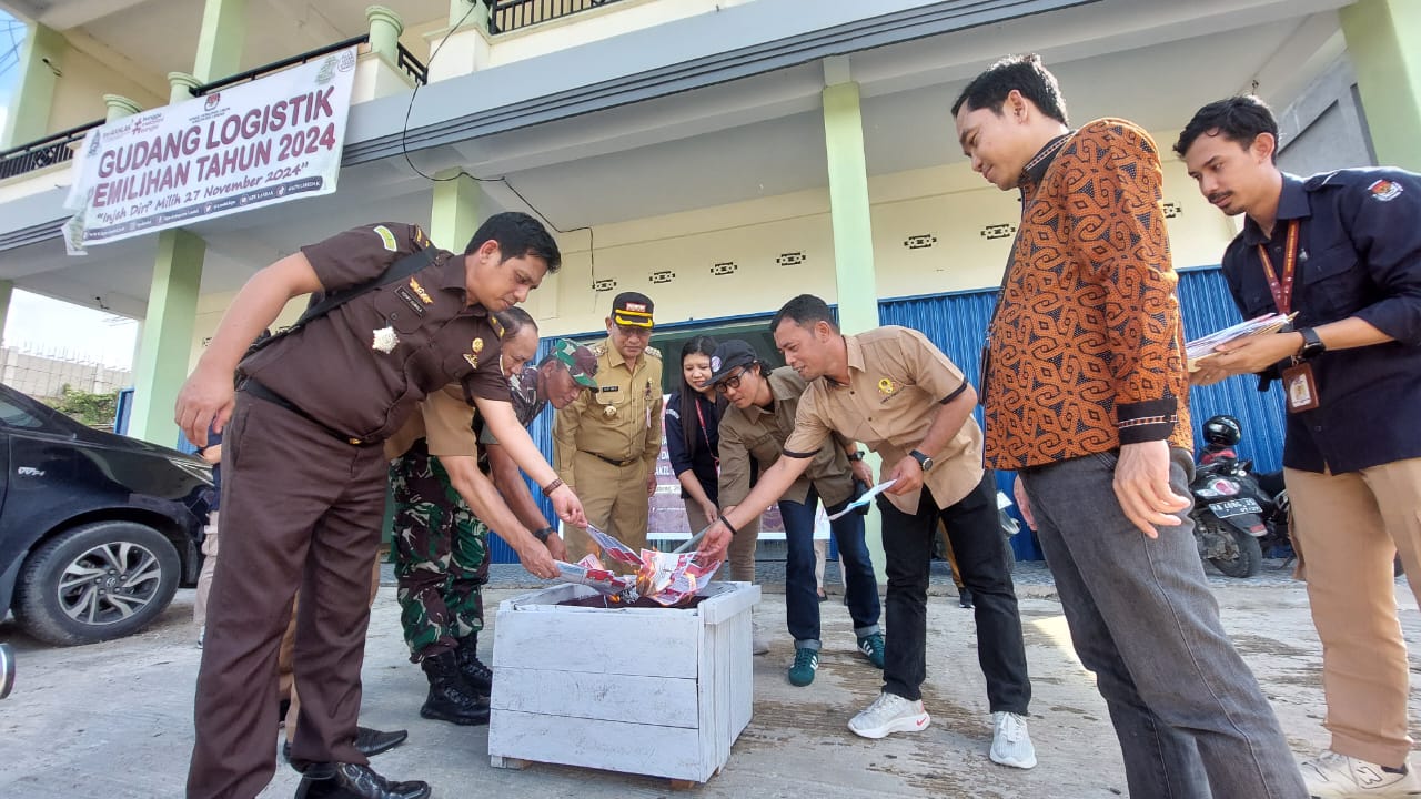 Pj Bupati Gutmen Nainggolan bersama KPU Kabupaten Landak melakukan pemusnahan surat suara rusak di depan gudang logistik pemilu.