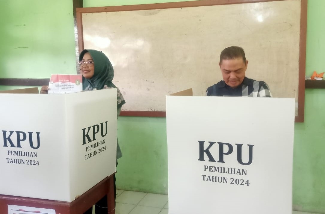 Cagub Kalbar Ria Norsan dan Cabup Mempawah Erlina menggunakan hak suaranya di TPS 14 Kelurahan Terusan.